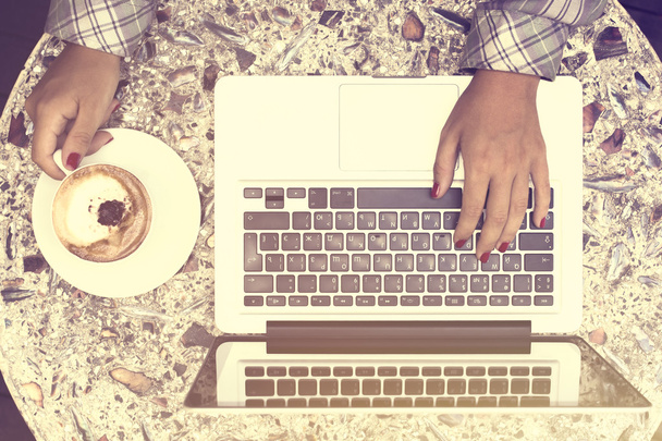 Mãos de menina com café e laptop
 - Foto, Imagem