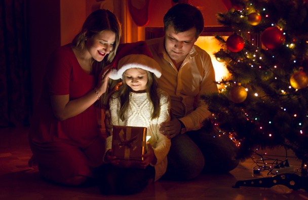 parents et fille mignonne regardant à l'intérieur du cadeau de Noël
 - Photo, image