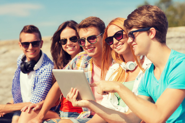 group of smiling friends with tablet pc outdoors - 写真・画像