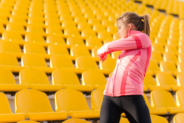 Fitness woman warming up at stadium - Foto, Imagem