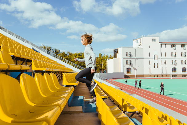 Mujer deportiva corriendo en el estadio
 - Foto, Imagen