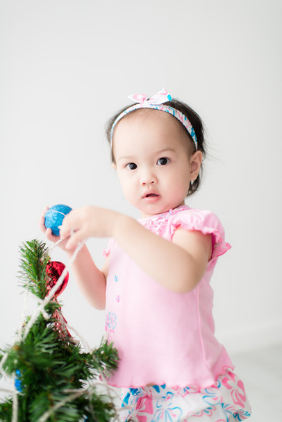 Chica ayudando a decorar el árbol de Navidad
 - Foto, imagen