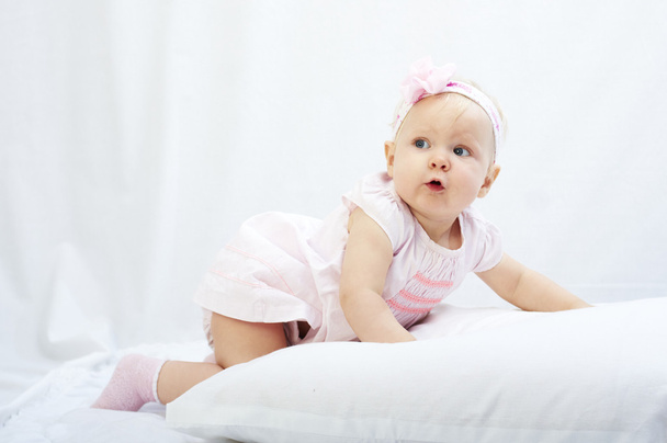 baby is playing with pillow over white background - Fotó, kép
