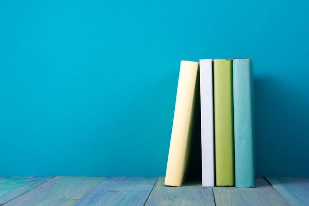 Rij van kleurrijke boeken, grungy blauwe achtergrond, presentexemplaar ruimte - Foto, afbeelding