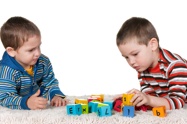 Hermanos jugando bloques en la alfombra
 - Foto, Imagen