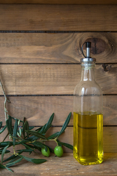 Oliven und eine Flasche Öl, Lebensmittel mit Holzhintergrund - Foto, Bild