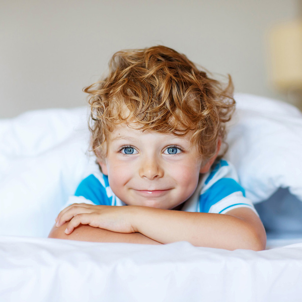 Adorabile ragazzo bambino dopo aver dormito nel suo letto bianco
 - Foto, immagini