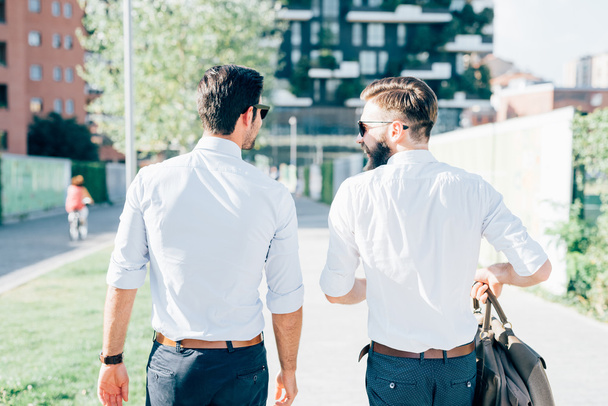 два современных бизнесмена прогуливаются по городу
 - Фото, изображение