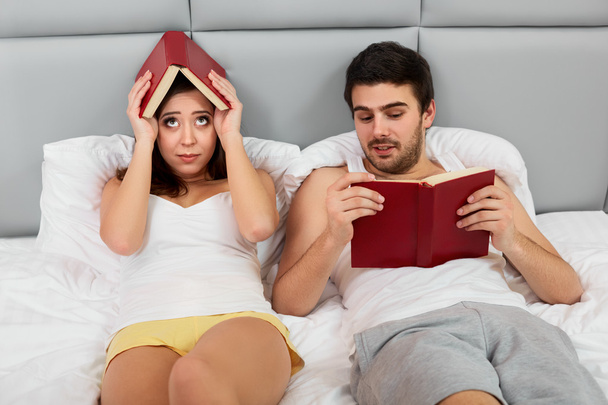 Happy Couple Sitting in Bed Reading Books at Home in Bedroom - Foto, imagen