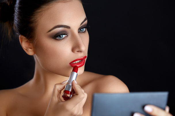 Red lips.  Beutifull Woman Doing Makeup Applying lipstick - Fotoğraf, Görsel