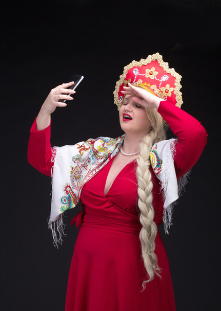Chica de pie en traje tradicional ruso con teléfono móvil - Foto, imagen