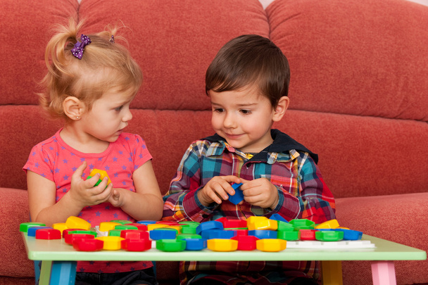 Мальчик и девочка играют за столом
 - Фото, изображение