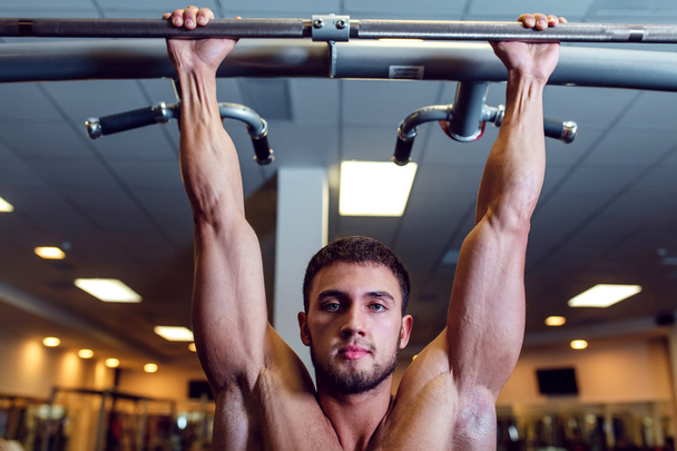 Very power athletic guy bodybuilder , execute exercise with horizontal bar - Φωτογραφία, εικόνα