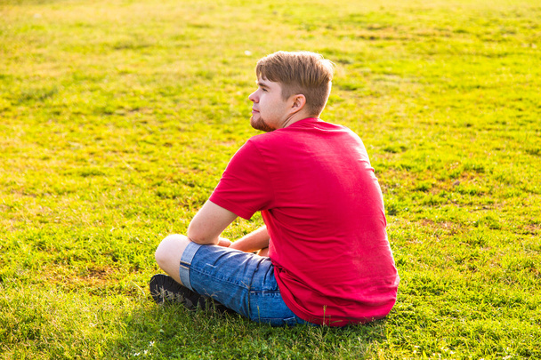 hombre sentado en la hierba - Foto, Imagen