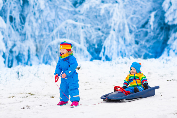Kids having fun on a sleigh ride in winter - Photo, Image