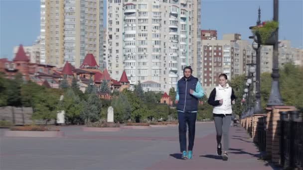 Ασκήσεις γυμναστικής, υγιείς δρομείς που τρέχουν στον ορίζοντα του αστικού τοπίου της πόλης - Πλάνα, βίντεο