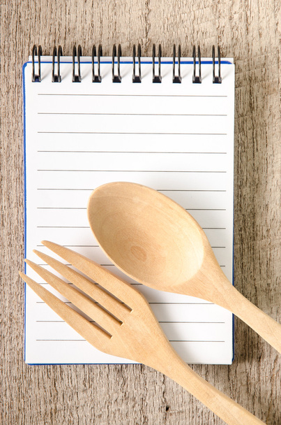 Open kookboek en keukengerei op houten achtergrond - Foto, afbeelding
