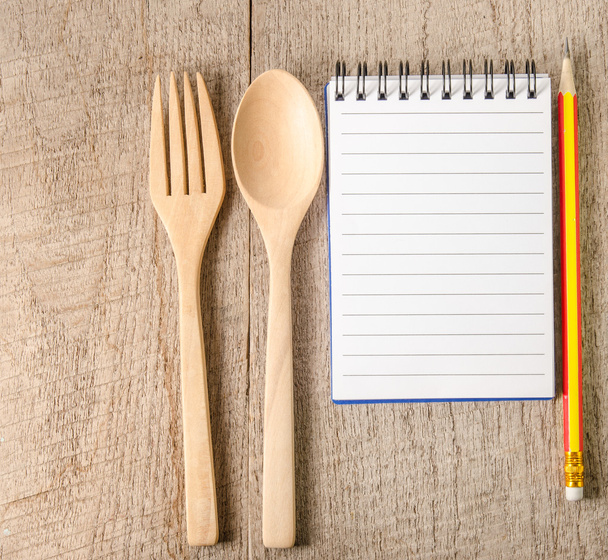 Livre de cuisine ouvert, crayon et ustensiles de cuisine sur fond en bois
 - Photo, image