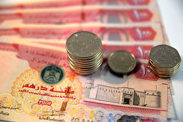 Крупный план различных банкнот и монет Объединенных Арабских Эмиратов
 - Фото, изображение