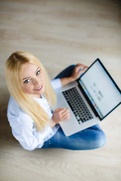 Щаслива молода красива жінка з ноутбуком в приміщенні
 - Фото, зображення