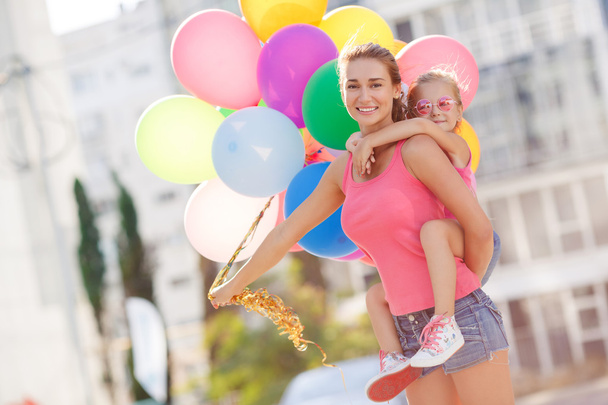 Мать и ребенок с цветными воздушными шарами
 - Фото, изображение