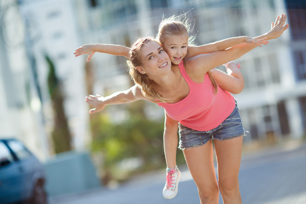 Happy mother and her daughter playing outdoors in summer. - Photo, Image