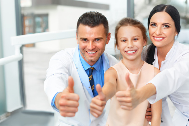 Dentist doctor,  assistant and little girl all smiling at camera - Foto, Imagem