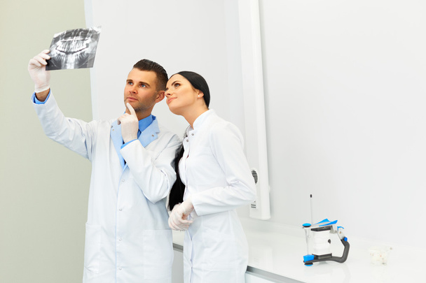 Dentist and female assistant are discussing dental X Ray image - Zdjęcie, obraz