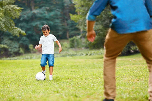 Summer football. Dad and son playing soccer. - Foto, afbeelding