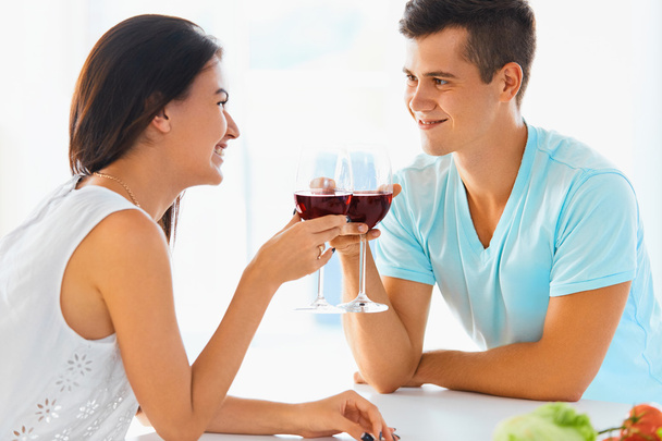 Portrait of couple clinking their glasses of red wine in the kit - Photo, image