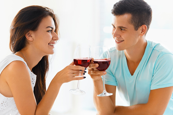Couple clinking their glasses of red wine. - Valokuva, kuva