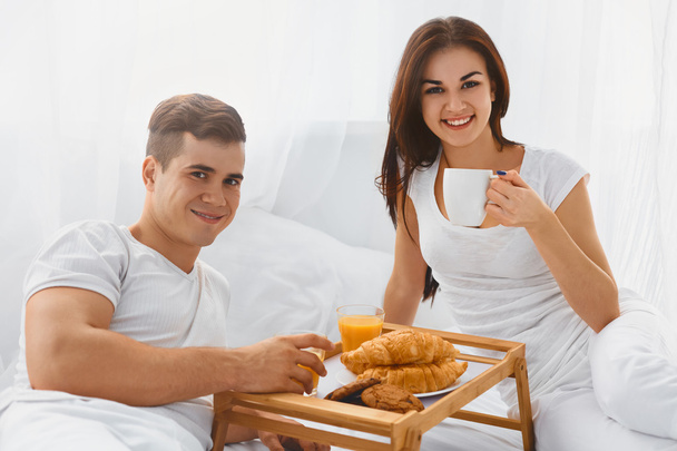 Portrait of couple enjoying breakfast in bed - Φωτογραφία, εικόνα