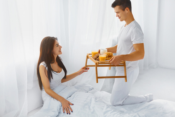 Man surprising woman with breakfast in bed - Foto, Imagem