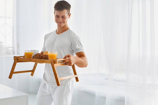 Young man with  breakfast in bed - Foto, imagen