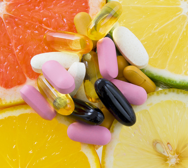 Groupe de pilules sur tranches de fruits (orange, citron, citron vert, pamplemousse)
 - Photo, image