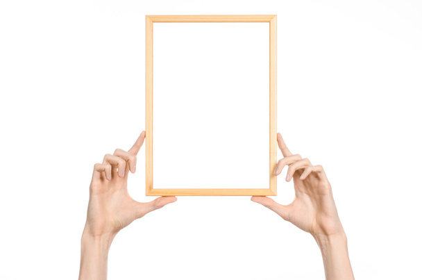 Huis decoratie en Photo Frame onderwerp: menselijke hand met een houten fotolijstje geïsoleerd op een witte achtergrond in studio - Foto, afbeelding