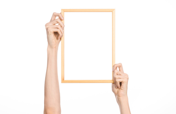 House decoration and Photo Frame topic: human hand holding a wooden picture frame isolated on a white background in studio - Fotó, kép