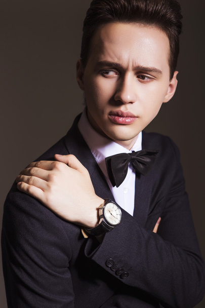 Young handsome brunette macho businessman in black suit and bow - Photo, Image