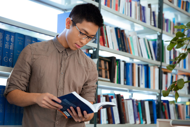 Asian man reading book in library - Zdjęcie, obraz