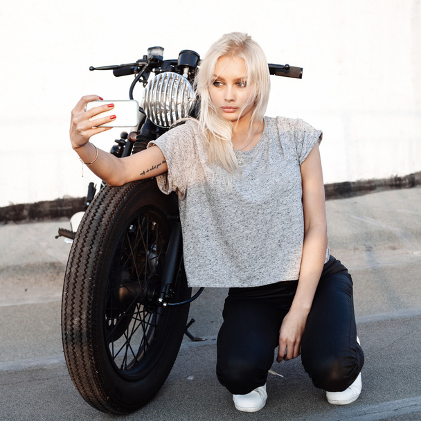 female biker girl making self portrait with vintage motorbike - Fotografie, Obrázek