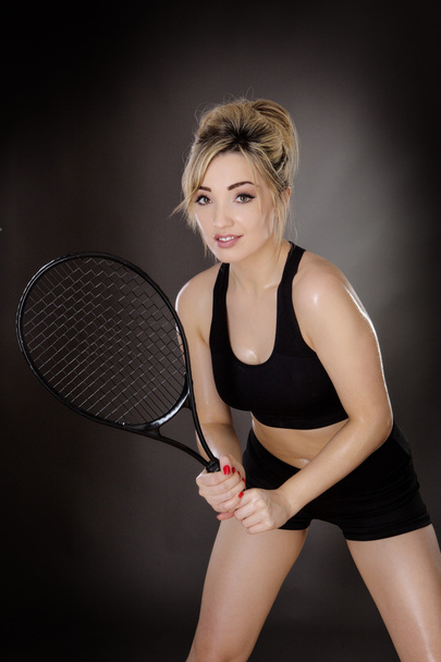 Спортсменка держит теннисную ракетку
 - Фото, изображение