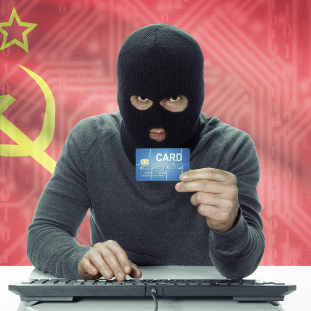 Dark-skinned hacker with flag on background holding credit card in hand - USSR - Soviet Union - Foto, immagini
