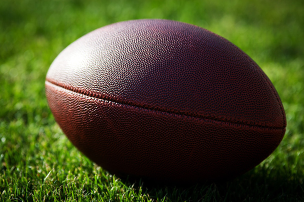 Close up of an american football on the field, players in the ba - Photo, Image