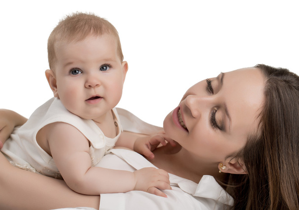 Happy young mother tenderly holding her daughter - Photo, image