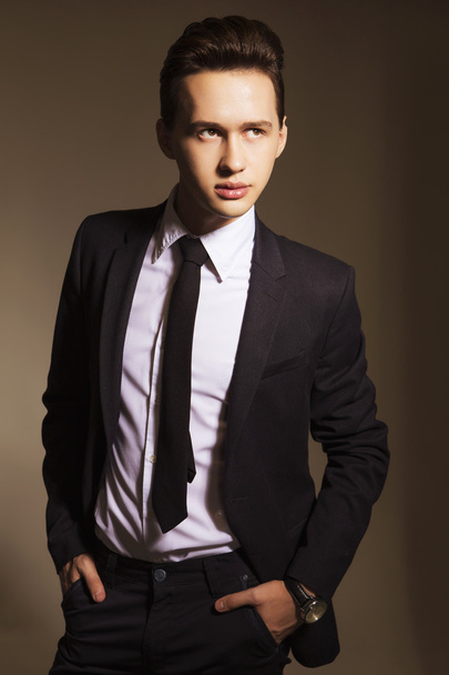 Young handsome brunette macho businessman in black suit and tie. - Photo, Image