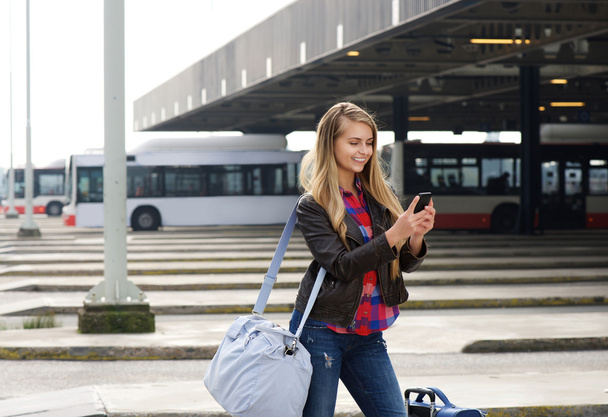 Молодая женщина путешественница смотрит на мобильный телефон
 - Фото, изображение