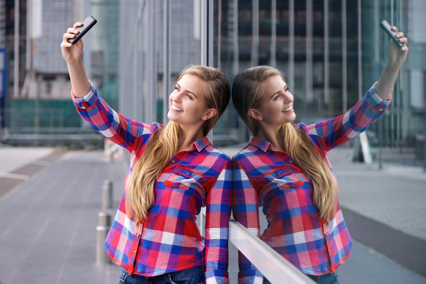 Lächelnde junge Frau macht Selfie mit Spiegelung - Foto, Bild