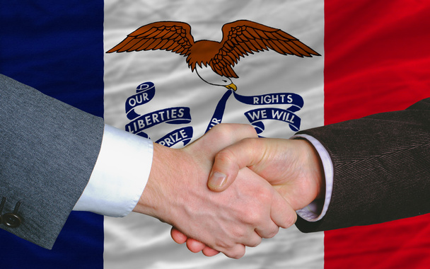 Перед американским государственным флагом Айова два бизнесмена рукопожали
 - Фото, изображение