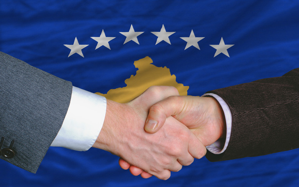 Devant le drapeau de kosovo deux hommes d'affaires poignée de main après bon
 - Photo, image