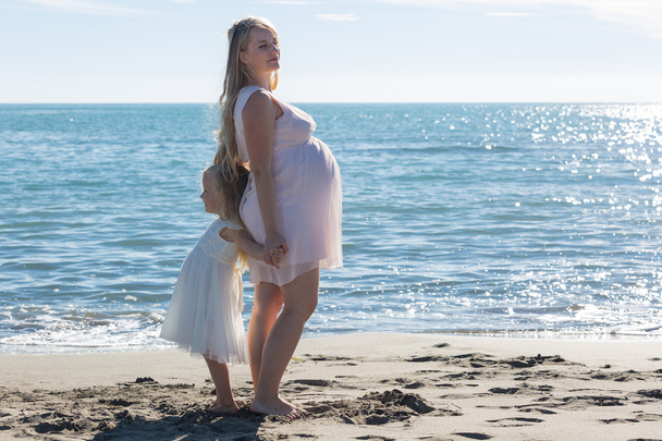 Portrait of a beautiful pregnant woman and daughter - Фото, зображення
